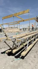 Set glulam beams with trusses on ground.